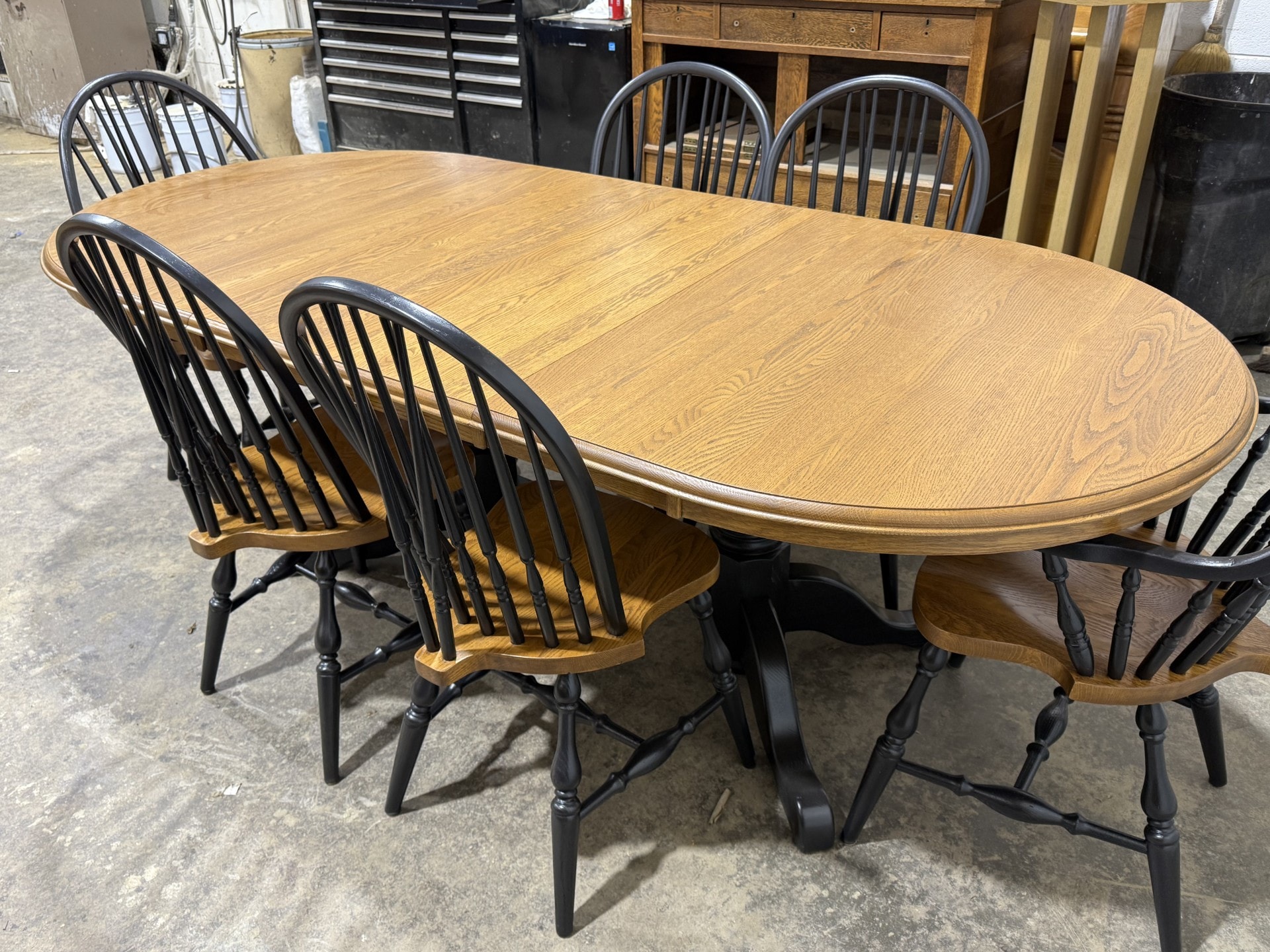 Wooden oval dining table with black chairs