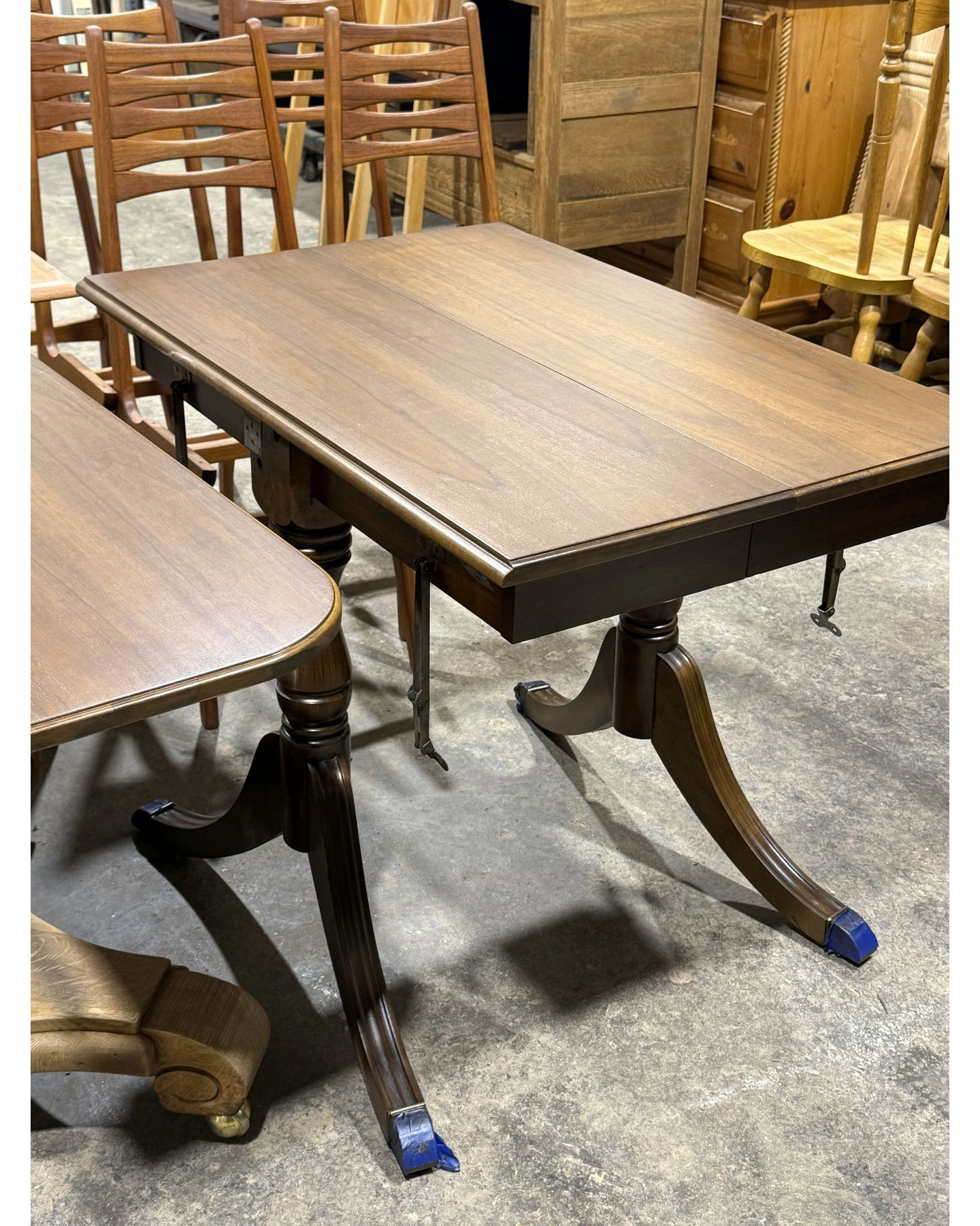 Two-tone dining table with light wood top and dark pedestal base