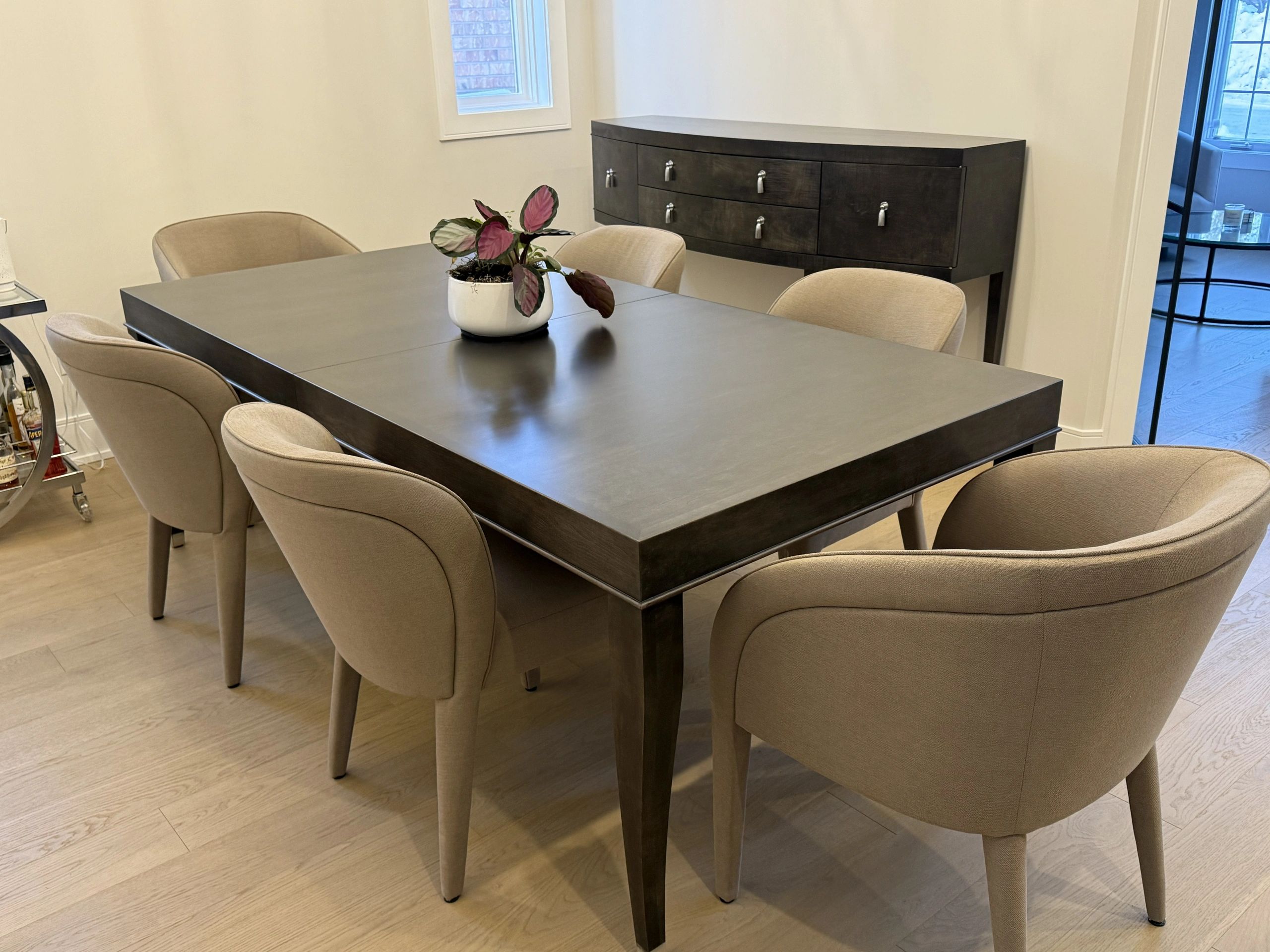Modern dining room with black table and beige upholstered chairs